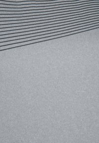 La tela gris presenta franjas negras horizontales en la parte superior, que se van transformando en un suave gris sólido en la parte inferior. Textura suave y superficie uniforme.