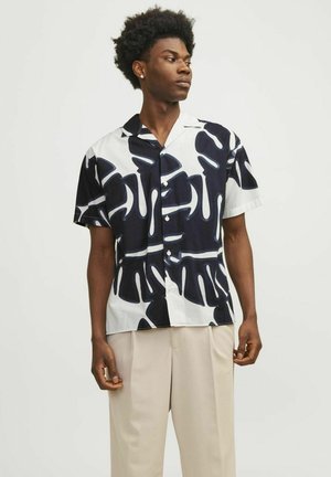 Camisa de manga corta con un patrón abstracto en blanco y negro, fabricada en tela ligera, con cuello clásico y botón en la parte delantera.