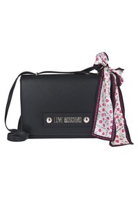 Borsa a tracolla in finta pelle nera con patta, hardware in argento e un tocco di sciarpa decorativa con labbra e disegni giocosi. Include una tracolla.