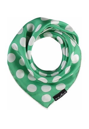 Grønt silketørklæde med store hvide polkaprikker, foldet i en cirkulær form, med en sort stoffisk tag med hvid tekst.