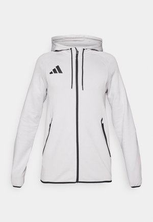 Λευκό φούτερ με φερμουάρ, με μαύρο λογότυπο και λεπτομέρειες. Διαθέτει κουκούλα, κορδόνια και πλαϊνές τσέπες. Λείο ύφασμα με εφαρμοστό σχέδιο.