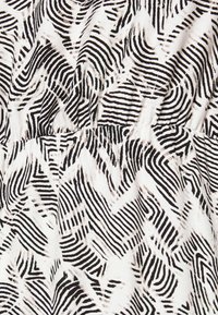 Bílá látka s černým a béžovým abstraktním vzorem nepravidelných čar a tvarů, tvořící vlnkovou texturu.