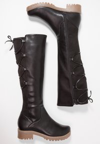 Černé vysoké boty po kolena se zipem na boku, šněrováním na zadní straně, kulatou špičkou a robustní béžovou gumovou podrážkou.