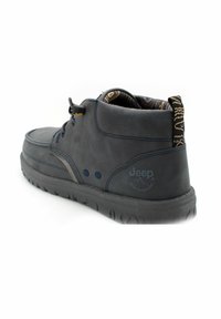 Stivaletti alla caviglia in suede blu navy con suole in gomma nera e accenti testurizzati; presentano una fodera a motivo e un logo Jeep sul tallone.