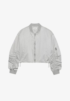 Kratka bomberska jakna iz svetlo sive najlonske tkanine, z značilnim sprednjim zadrgo, rebrastim ovratnikom, nabranimi rokavi in stransko žepno z zadrgo.