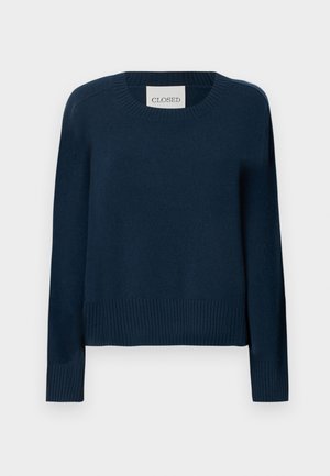 Mörkblå tröja med ribbad rund halsringning och fåll, långa ärmar och avslappnad passform. Tillverkad av ett mjukt stickat material med minimal detaljering.