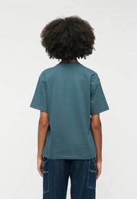 Σκούρο μπλε κοντομάνικο μπλουζάκι με στρογγυλή λαιμόκοψη, κατασκευασμένο από μείγμα βαμβακιού, που διαθέτει άνετη εφαρμογή και λεία υφή.