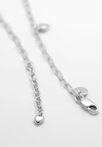 Collana in argento con maglie ovali, un piccolo ciondolo a forma di cuore e un gancio a molla. Texture liscia con una finitura lucida.