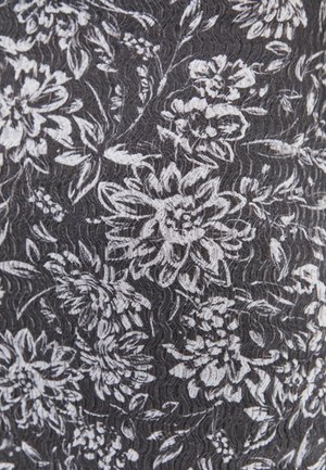 Tejido negro con un patrón floral blanco, texturizado con un sutil efecto ondulado, que muestra intrincados diseños de flores y formas orgánicas.