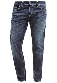 Mörkblå denimjeans med en urtvättad, sliten textur, med subtila ljusa stänk, kontrasterande sömmar och en klassisk femficksdesign.