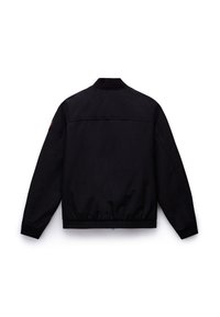 Veste bomber noire avec col, poignets et ourlet côtelés, vue de dos, avec un petit écusson rond sur la manche gauche.