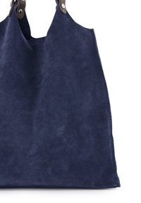 Marinblå suedetotepose med toppehåndtag, der har en glat overflade og metalhardwaredetaljer. Enkel, ustruktureret design.