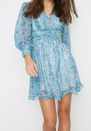 Abito blu con motivo paisley, maniche lunghe trasparenti, vita arricciata e gonna svasata. Tessuto leggero e fluido con una sottile lucentezza.