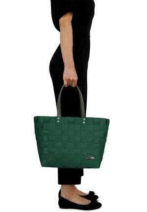 Grüne geflochtene Tragetasche aus gummiähnlichem Material mit zwei grauen Griffen und silbernen Hardware-Akzenten. Verfügt über ein strukturiertes Muster.