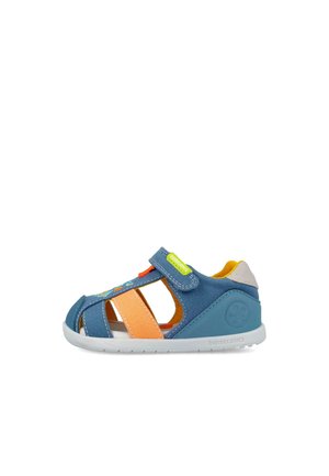Sandalia para niño pequeño en azul y naranja con suela blanca, diseño de puntera abierta, tira de velcro y forro interior amarillo.