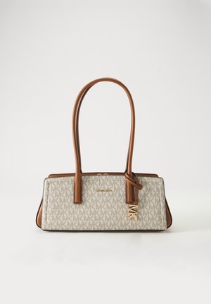 Prostokątna beżowa torebka z brązowymi skórzanymi uchwytami, wzorem monogramu MK oraz złotym logo i zawieszką Michael Kors z przodu.