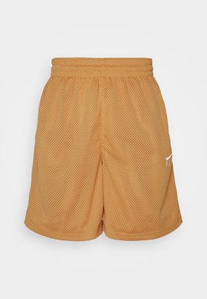 Lysebrune sportsshorts i mesh med elastisk talje og lille hvidt Nike-logo på højre ben mod en ensfarvet baggrund.