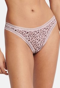 Gennemsigtigt lyserødt undertøj med polkaprikket mønster i forskellige nuancer af brunt, med delikat blonderkant langs taljebåndet.