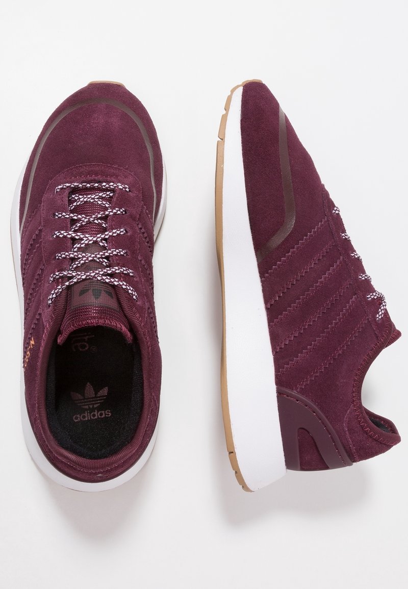 Maroon suede athletic shoes with white rubber sole, textured laces, and gum rubber accents. Features logo on tongue and side.