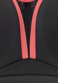 Reggiseno sportivo nero con pannello in rete e rifiniture e cuciture in corallo brillante, progettato con una forma strutturata e una texture liscia.