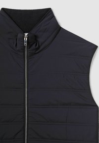 Vest negru izolat cu guler înalt, având modele quilted orizontale și închidere cu fermoar în față. Textură de țesătură netedă, ușoară.