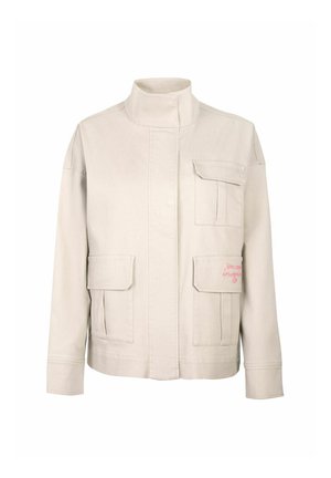 Beige jacket with a high collar, four front pockets, and a textured fabric. Notable pink embroidered text on the lower pocket.
