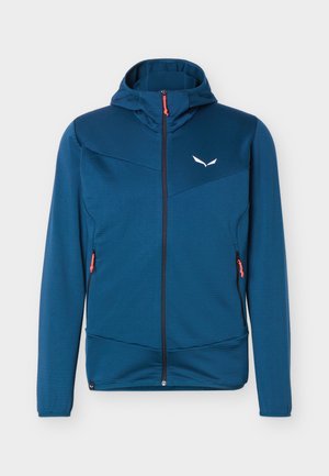 Blauwe jas met volledige ritssluiting, capuchon en lange mouwen, twee zakken met rits met rode trekers en een klein wit logo op de linkerkant van de borst.