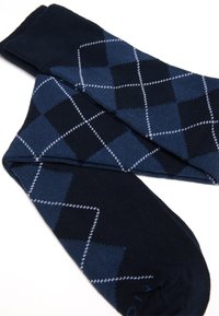 Calzini blu navy con motivo argyle in diverse tonalità di blu, con contorni a forma di diamante bianchi e un tessuto morbido e testurizzato.