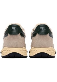 Scarpe da ginnastica in suede beige con accenti in pelle verde e una suola intermedia cremosa e strutturata. La suola esterna presenta un motivo a stella per una migliore presa.