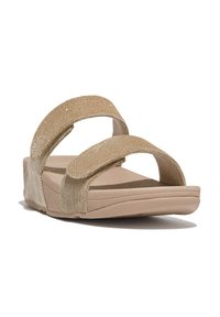 Sandalias beige con dos correas anchas de tela dorada texturizada. Suela acolchada, tacón ligeramente elevado. Diseño simple y moderno con una base plana.