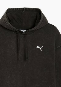 Čierna mikina s kapucňou a sťahovacími šnúrkami, s malým bielym logom Puma na ľavom hrudníku, zobrazuje mäkkú, mierne štruktúrovanú tkaninu.
