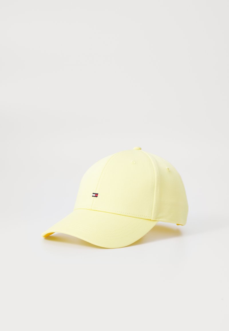 Casquette de baseball jaune avec une visière incurvée, fabriquée en tissu lisse, comportant un petit logo brodé en noir, rouge et blanc à l'avant.