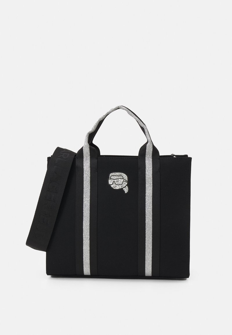 Borsa tote in tela nera con strisce argento, manici robusti e chiusura con zip. Presenta una grafica decorativa sulla parte anteriore.