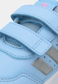 Μπλε συνθετικό αθλητικό παπούτσι με δύο λουριά βέλκρο, πάνελ από δίχτυ, ασημένιες λεπτομέρειες και υφασμένο πέλμα. Ραφτές λεπτομέρειες κατά μήκος των άκρων.