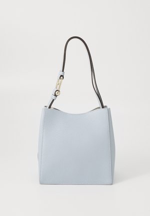 Sac à main en cuir texturé bleu clair avec une fine bandoulière noire réglable et des détails en métal doré sur fond blanc.