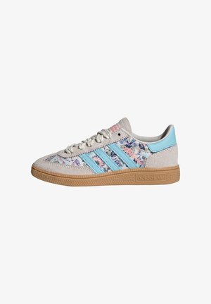 Lage Adidas sneaker met beige suède, blauwe strepen, bloemmotief op stoffen zijden, gumzool en vetersluiting.