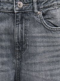 Lähikuva harmaista farkuista, joissa näkyvät nappi, vetoketjualue ja oikean etutaskun ompeleet sekä metallinen niitti.