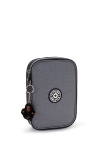 Étui gris avec fermeture éclair, au fini texturé, arborant un logo circulaire Kipling et un porte-clés en forme de singe noir en accent.