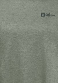 Lichtgroene t-shirt met korte mouwen van een gestructureerde stof. Bevat een klein blauw logo in de linkerbovenhoek. Ronde halslijn.