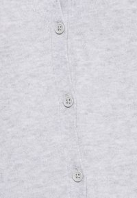 Jasnoszary kardigan wykonany z miękkiego, dzianinowego materiału, z sześcioma okrągłymi szarymi guzikami na przednim kołnierzu. Gładka faktura z subtelnym wzorem.