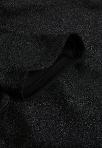 Black glittery fabric with a smooth texture; features a hidden zipper opening. The sparkly surface reflects light, creating visual interest.