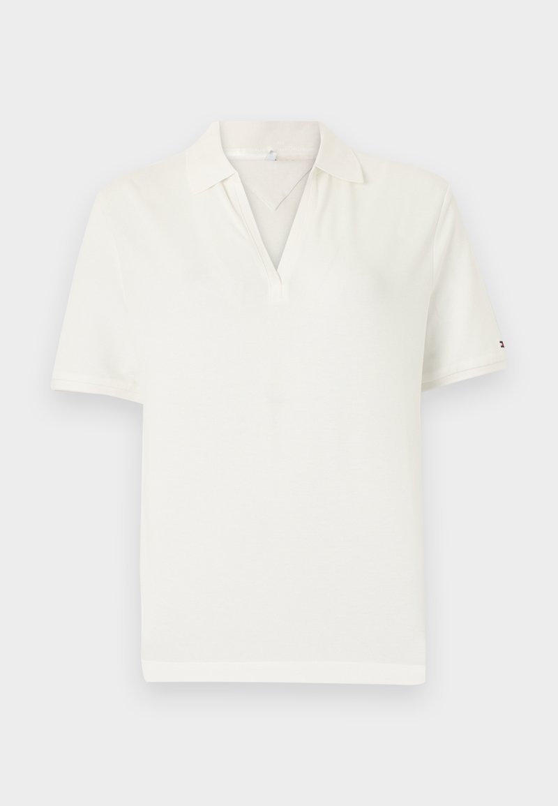 Λευκό πόλο πουκάμισο με V-λαιμόκοψη και κοντά μανίκια. Κατασκευασμένο από απαλό ύφασμα, με διακριτική λεπτομέρεια λογοτύπου στο μανίκι. Καθαρός και μίνιμαλ σχεδιασμός.