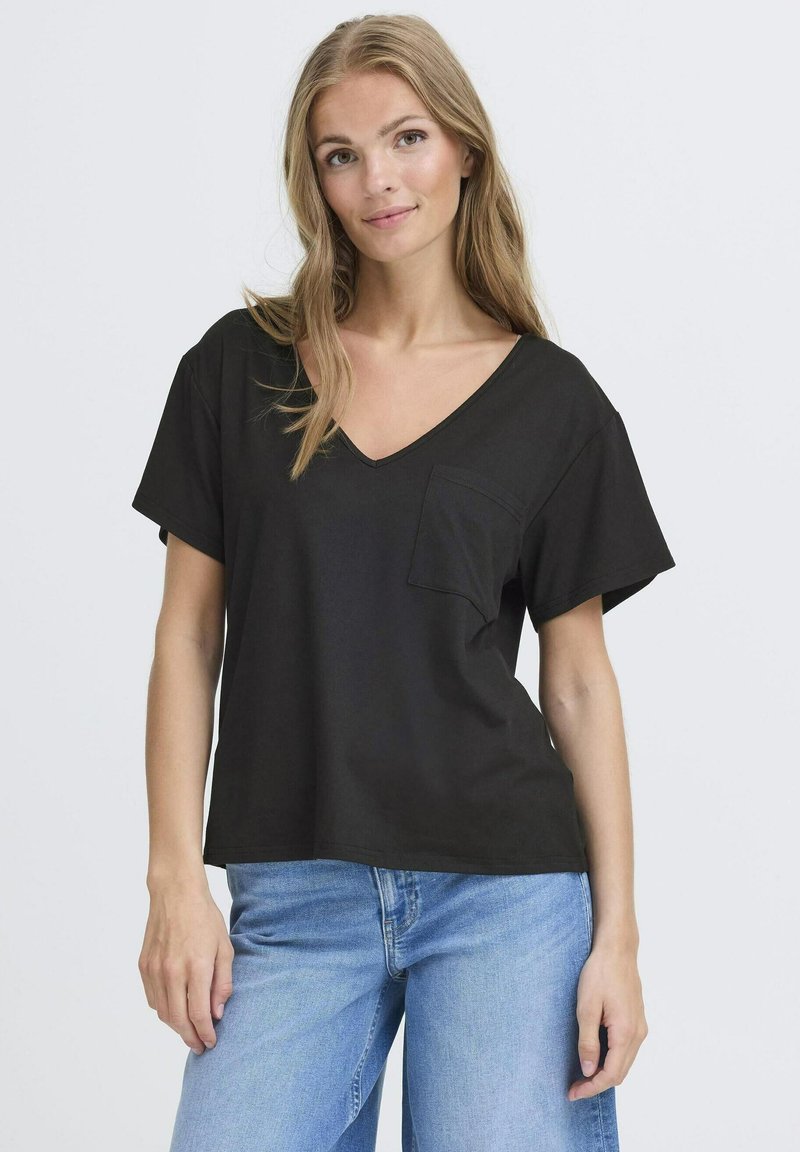 Tricou negru cu decolteu în V, cu mâneci scurte, având un buzunar pe piept. Material neted, cu o croială lejeră. Asortat cu blugi albaștri deschiși.