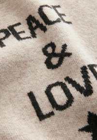 Tessuto a maglia di un rosa chiaro con un testo nero ben visibile che recita “PEACE & LOVE.” Texture morbida con una leggera peluria, senza ulteriori motivi o dettagli.