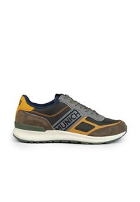Baskets de sport avec mesh gris, daim marron, accents jaunes et un logo "MUNICH" bien visible. Elles disposent d'une semelle rembourrée et de lacets multicolores.
