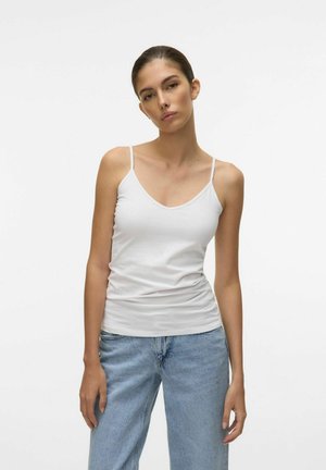 Top de algodón blanco sin mangas con tirantes finos, presenta un diseño de escote en V y una silueta ajustada. Combinado con jeans de mezclilla azul claro.