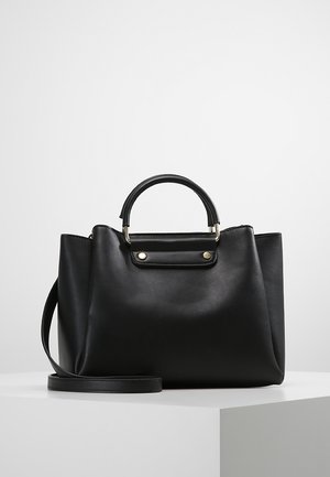 Czarna skórzana torebka z krótkimi, zaokrąglonymi uchwytami oraz regulowanym długim paskiem na ramię na białym tle.