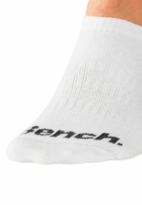 White ankle sock with ribbed texture, featuring a black logo printed on the toe area. Elasticated cuff for a secure fit.