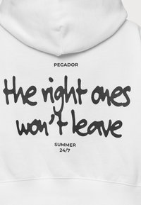 Sudadera blanca con texto grande en negro en la parte trasera que dice: "los correctos no se irán", con "PEGADOR" arriba y "SUMMER 24/7" abajo.