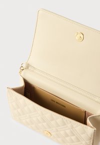 Μπεζ καπιτονέ πορτοφόλι από συνθετικό δέρμα με χρυσούς μεταλλικούς εξαρτήματα, διαθέτει μαγνητικό κούμπωμα και εσωτερικές θήκες για κάρτες.